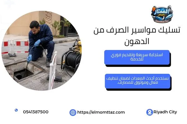 فني ينظف خط الصرف بضغط مياه متحكم فيه بجوار غرفة التفتيش